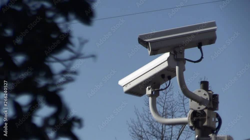 close up of a surveillance camera against blue sky, watching every move close up of a surveillance camera against blue sky, watching every move