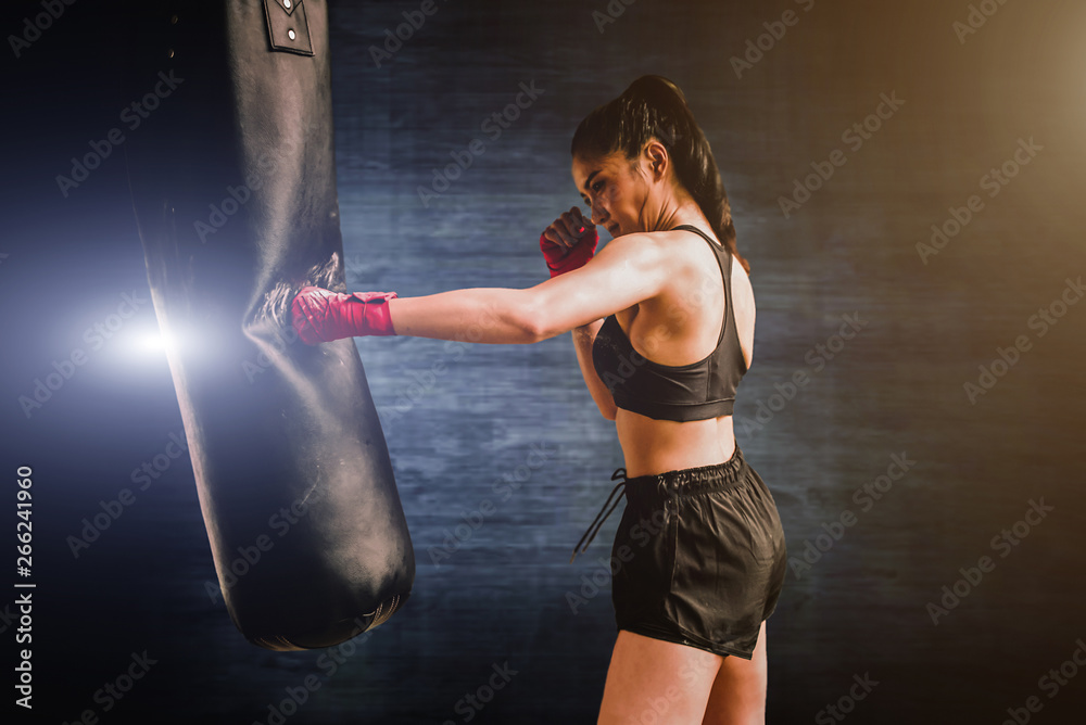 Female boxer hitting a huge punching bag. Woman boxer training actively and  hard. - Image foto de Stock | Adobe Stock