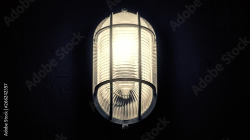 A scary flickering light lamp inside a basement, turning on and slightly off because of the unstable electrical current (or a paranormal phenomenon).