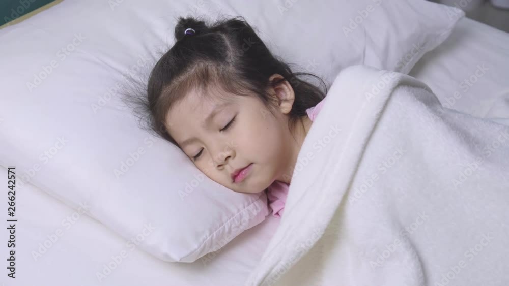 Happy child little asian girl sleeping with her teddy bear on the bed in her bedroom, Educational concept for homeschool Happy child little asian girl sleeping with her teddy bear on the bed in her bedroom, Educational concept for homeschool