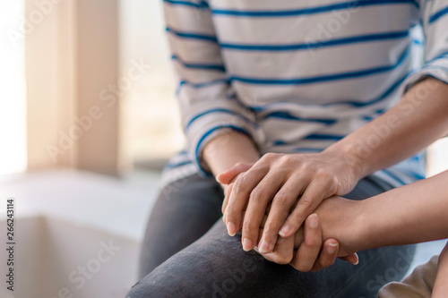 Young woman sitting and touch young depressed asian woman for encouragement near window, Selective focus, PTSD Mental health concept. photo