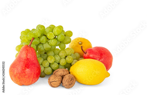 Fototapeta Naklejka Na Ścianę i Meble -  A pair of fragrant yellow lemons with a branch of ripe green grapes and bright scarlet delicious walnuts pears on a white background
