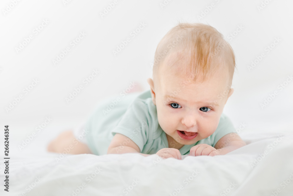 Portrait of beautiful infant baby lying on stomach in bed Portrait of beautiful infant baby lying on stomach in bed