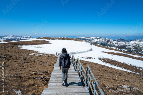 woman with a backpack walks on the snow mountains. photo