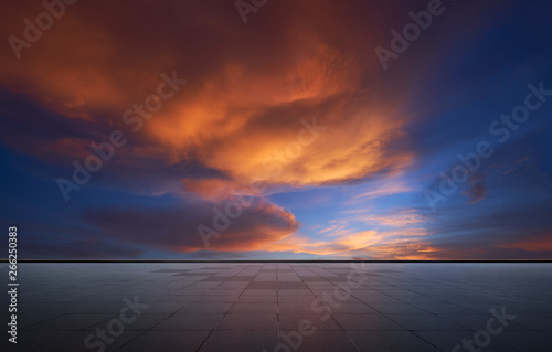 Beautiful vibrant orange cloud and blue sunset sky with empty asphalt floor . © jamesteohart