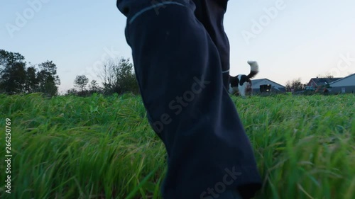 Farmer walking outside in grass and farm in sunshine photo