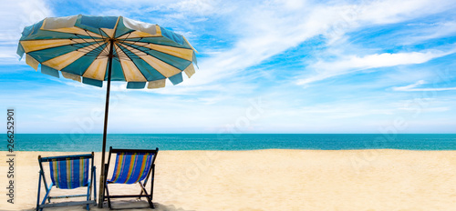 Beautiful scenery of double chairs and umbrellas on the beach, sea, blue sky of relaxation in the summer. Copy space banner