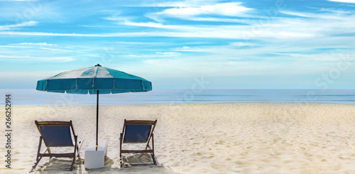 Beautiful scenery of double chairs and umbrellas on the beach, sea, blue sky of relaxation in the summer. Copy space banner