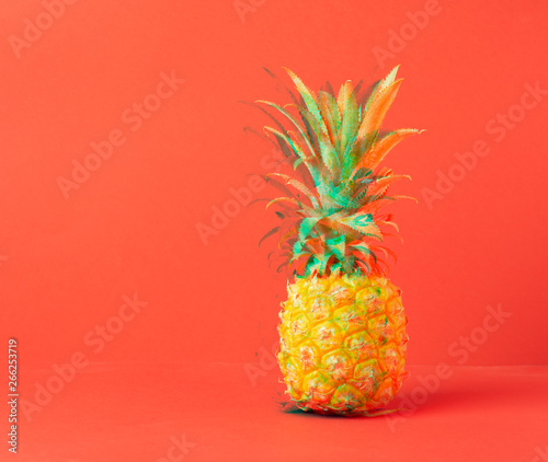 Yellow ripe pineapple on a red background. Concept minimalism. Glitch effect processing. Copy space. Horizontal