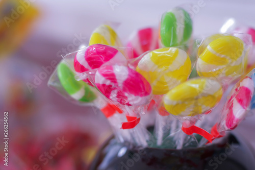 Colorful candy sweets inside black jar on the table.