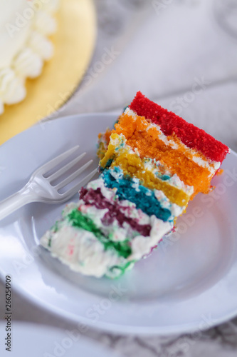 Colorful cake slice on white table.