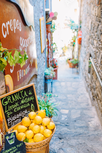Fototapeta Naklejka Na Ścianę i Meble -  Wicker basket full of lemons on the italian street od Corniglia