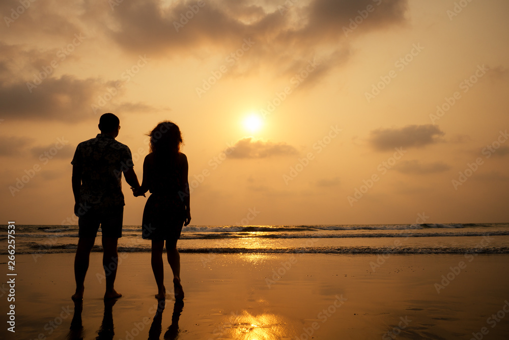 Young couple in love on the beach February 14, St. Valentine's Day sunset Goa India vacation trip .travel new year in a tropical country. freedom concept