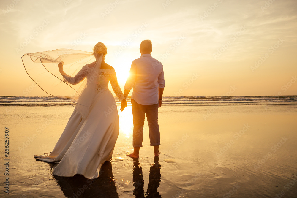 Fototapeta premium Young couple in love on the beach February 14, St. Valentine's Day sunset Goa India vacation trip .travel new year in a tropical country. freedom concept