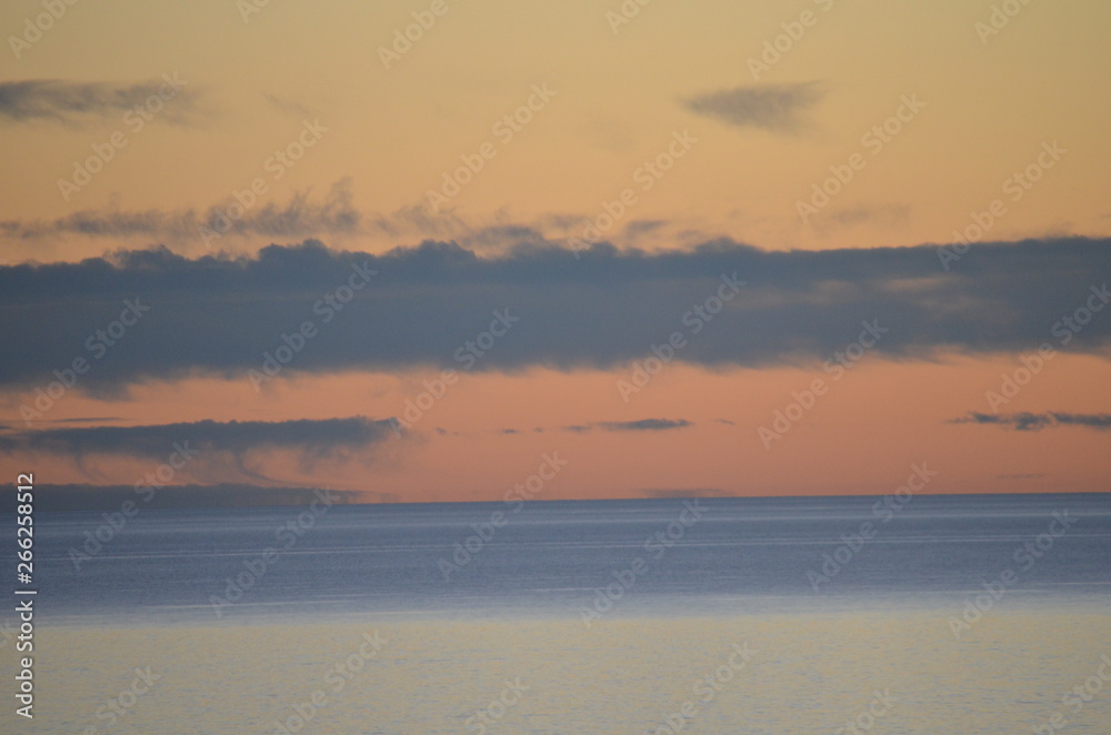 orange ocean sunset with gray clouds at Glenelg South Australia