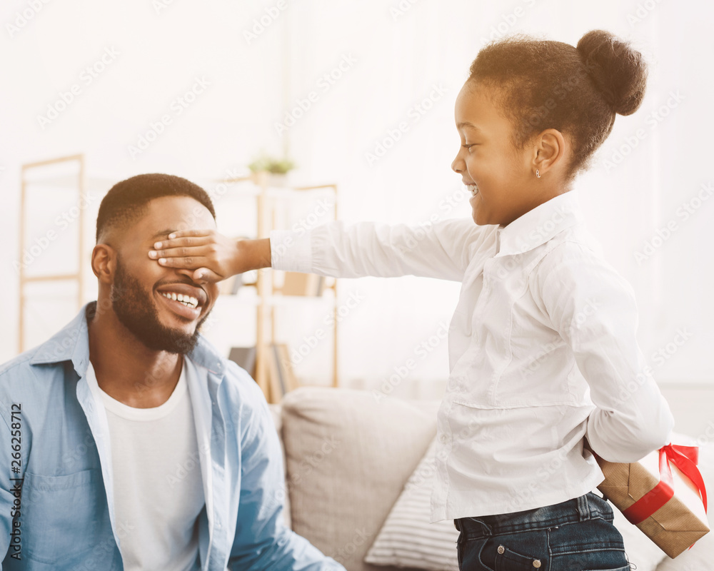 Little girl making surprise for dad, closing his eyes Little girl making surprise for dad, closing his eyes