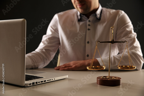 Close up view of lawer man working on a laptop. Libra and Statue of Justice photo