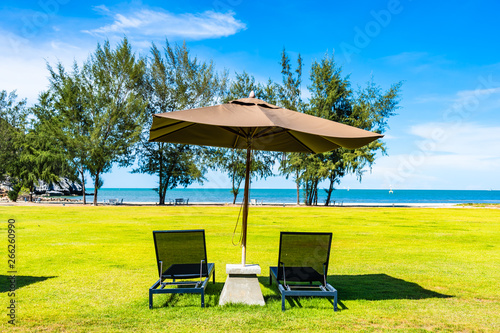 Umbrella and chair on the green grass nearly sea beach