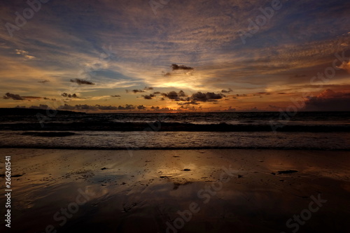 the beauty of Jimbaran beach in Bali Indonesia at dusk with the sun disappearing