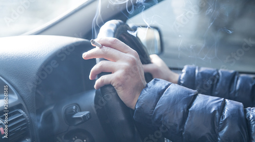 Man smoking a cigarette at the wheel of a car. Driving and smoking