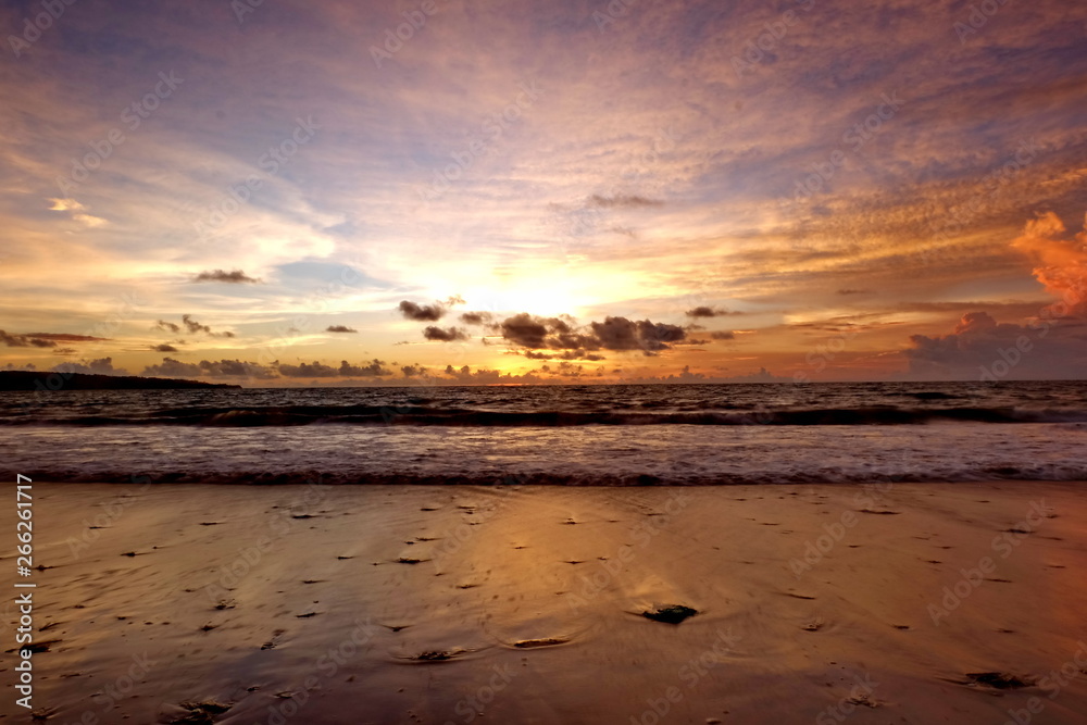 the beauty of Jimbaran beach in Bali Indonesia at dusk with the sun disappearing