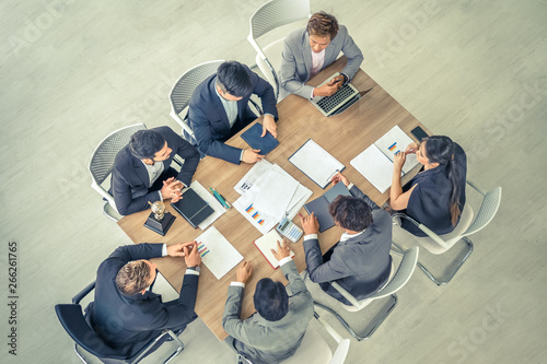 Business meeting. Top view of businessman executive in group meeting with other businessmen and businesswomen in modern office.