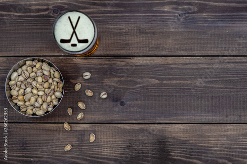 Beer and pistachios on dark wooden background. Top view. Empty space for text