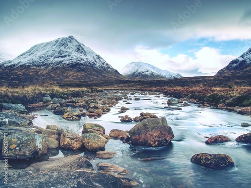 Pools and majestatic waterfalls belllow snowy mountains. Blue water photo