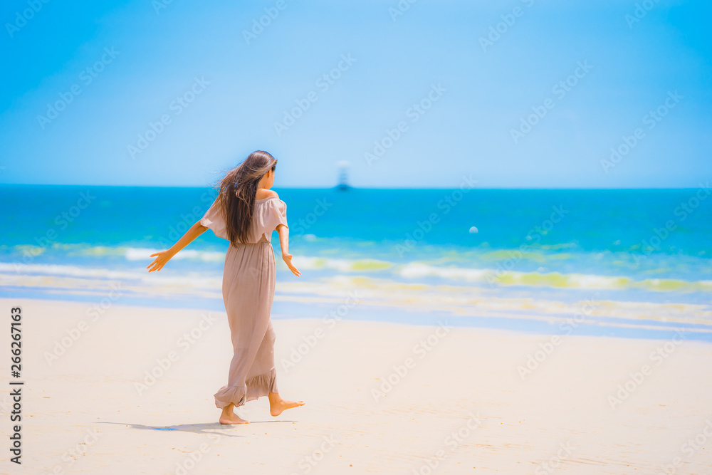 Portrait beautiful young asian woman smile happy walk on the tropical outdoor nature beach sea