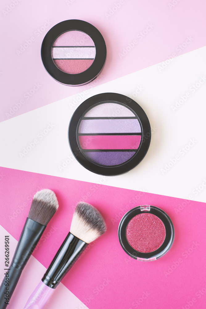 Eyeshadows and make up brush on a stripes background Eyeshadows and make up brush on a stripes background