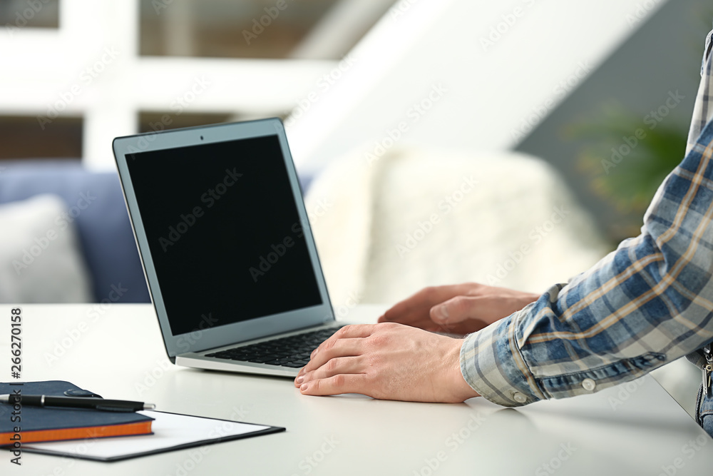 Young man using modern laptop at table Young man using modern laptop at table
