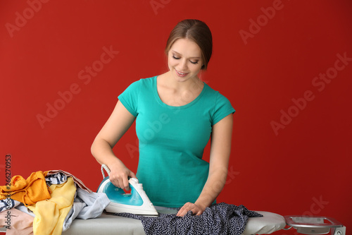 Young woman ironing clothes...