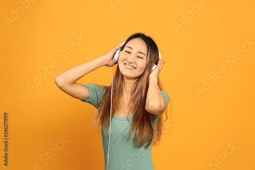 Asian woman listening to mu...
