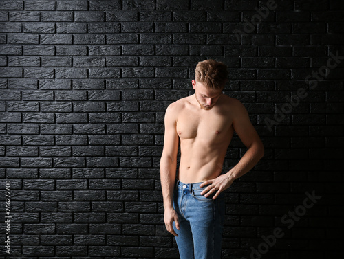 Sporty young man near dark brick wall