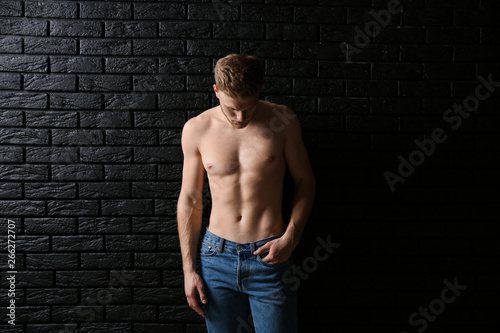 Sporty young man near dark brick wall