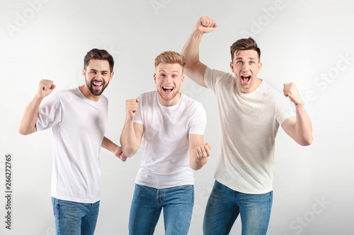 Happy young men on light background