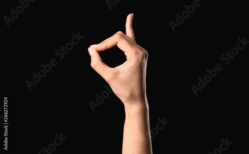Female hand showing letter D on dark background