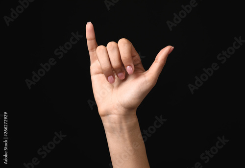 Female hand showing letter Y on dark background