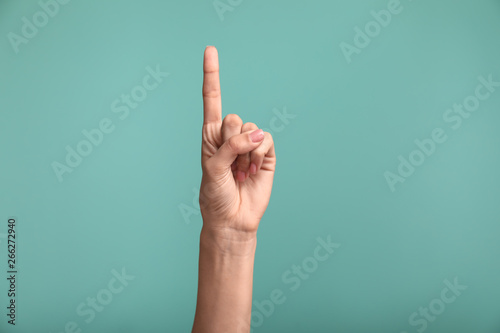 Gesturing female hand on color background photo