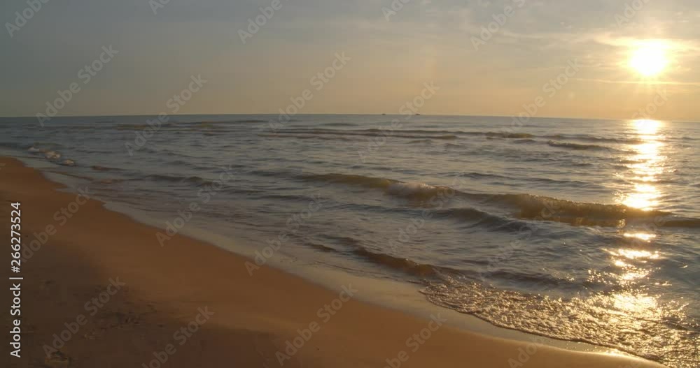 Static slow motion shot of waves gently rolling up onto the beach in late afternoon with sun off to right. Static slow motion shot of waves gently rolling up onto the beach in late afternoon with sun off to right.