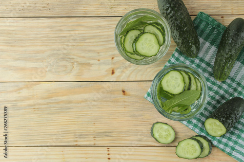 water with cucumber. Refreshing diet water with cucumber and mint in a glass beaker on a wooden background. detox drink concept. summer refreshing drink. top view