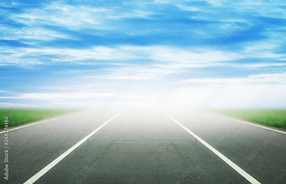 Fototapeta premium Background of blurred asphalt road, clear blue sky with clouds. Sunlit skyline