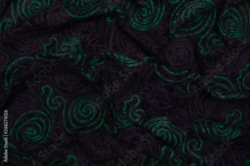 Creative dark fabric with green and violet patterns with textile texture background