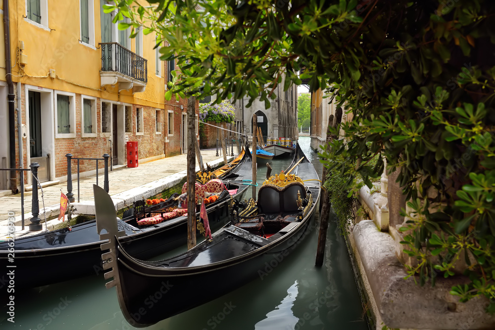 Pier of gondolas on narrow canal of Venice, Italy