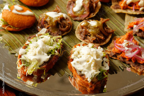 A sope is a traditional Mexican dish. This antojito is made from a circle of fried masa and topped with refried beans and crumbled cheese, lettuce, onions, red or green sauce, and sour cream.