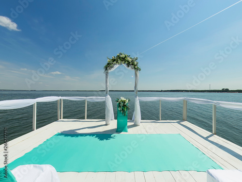 Place for wedding ceremony. Pier on bank of lake, Wedding arch © flyural66