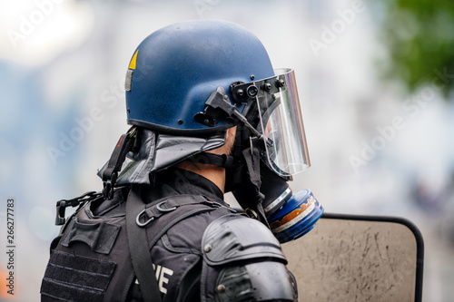 Rear view of police officer wearing gas mask against tear gas at protest with Yellow jackets Gilets Jaunes photo