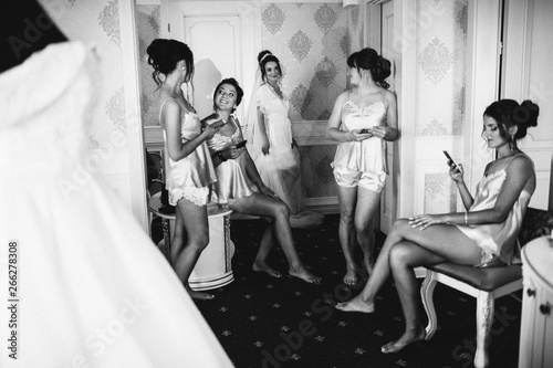 Wedding Girls Party. Happy bride with bridesmaid. Preparing bride before her wedding in room.