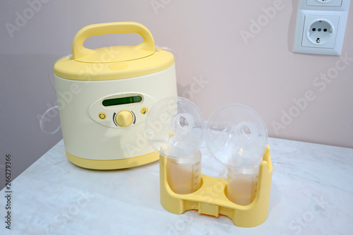 At the room for breast milk taking: milk pump placed on a table photo