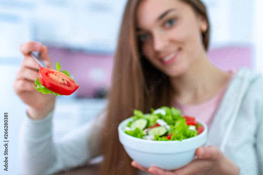 Portrait of young happy healthy woman eating fresh vegetable salad at home. Balanced diet and fitness eating. Clean and control food Portrait of young happy healthy woman eating fresh vegetable salad at home. Balanced diet and fitness eating. Clean and control food